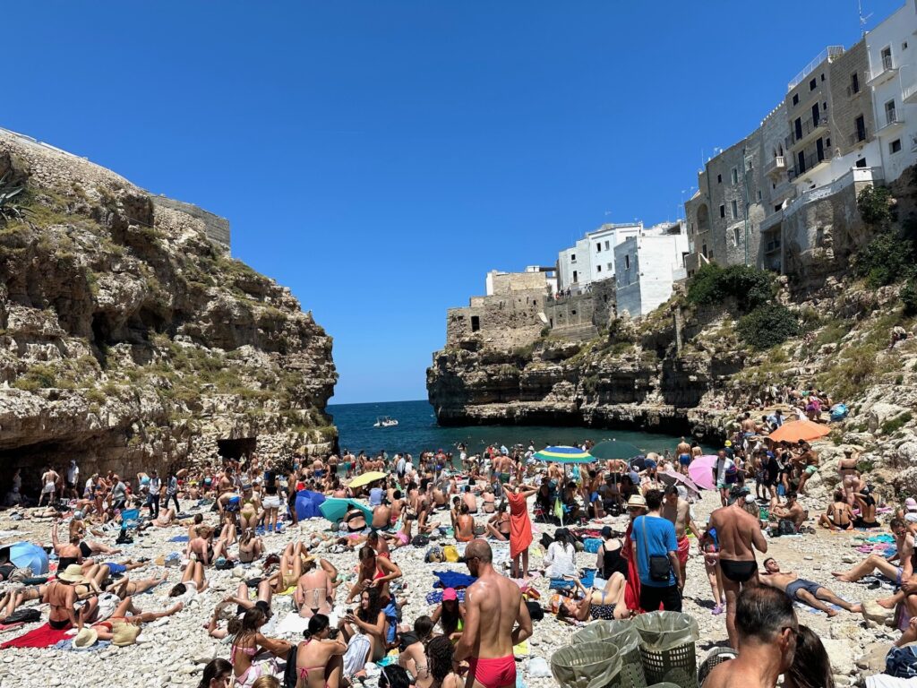 Packed Lama Monachile in Polignano A Mare, Italy on a busy, summer afternoon