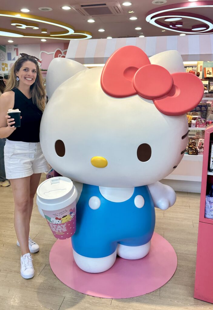 Kristy standing with Hello Kitty at the themed 7-11 in Taipei, Taiwan